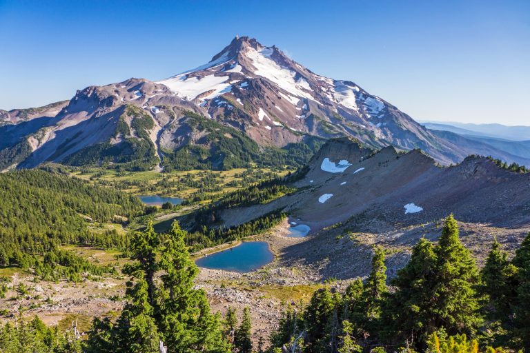 Paysage de montagne en altitude avec lac et sommet enneigé, destination idéale pour les stages sportifs et séjours d'entraînement