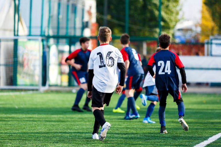 Jeunes joueurs de football lors d'un entraînement sur terrain synthétique pendant un stage sportif organisé par Sport'n Go